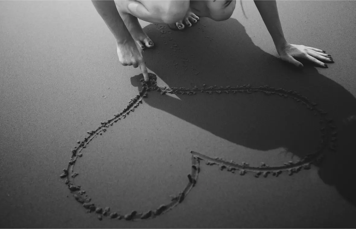 closeup hand drawing heart sand 1