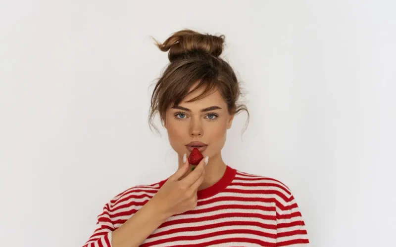 front view woman posing with strawberry
