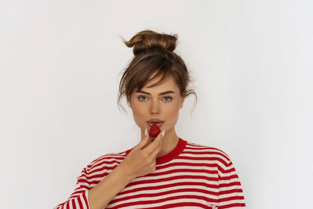 front view woman posing with strawberry